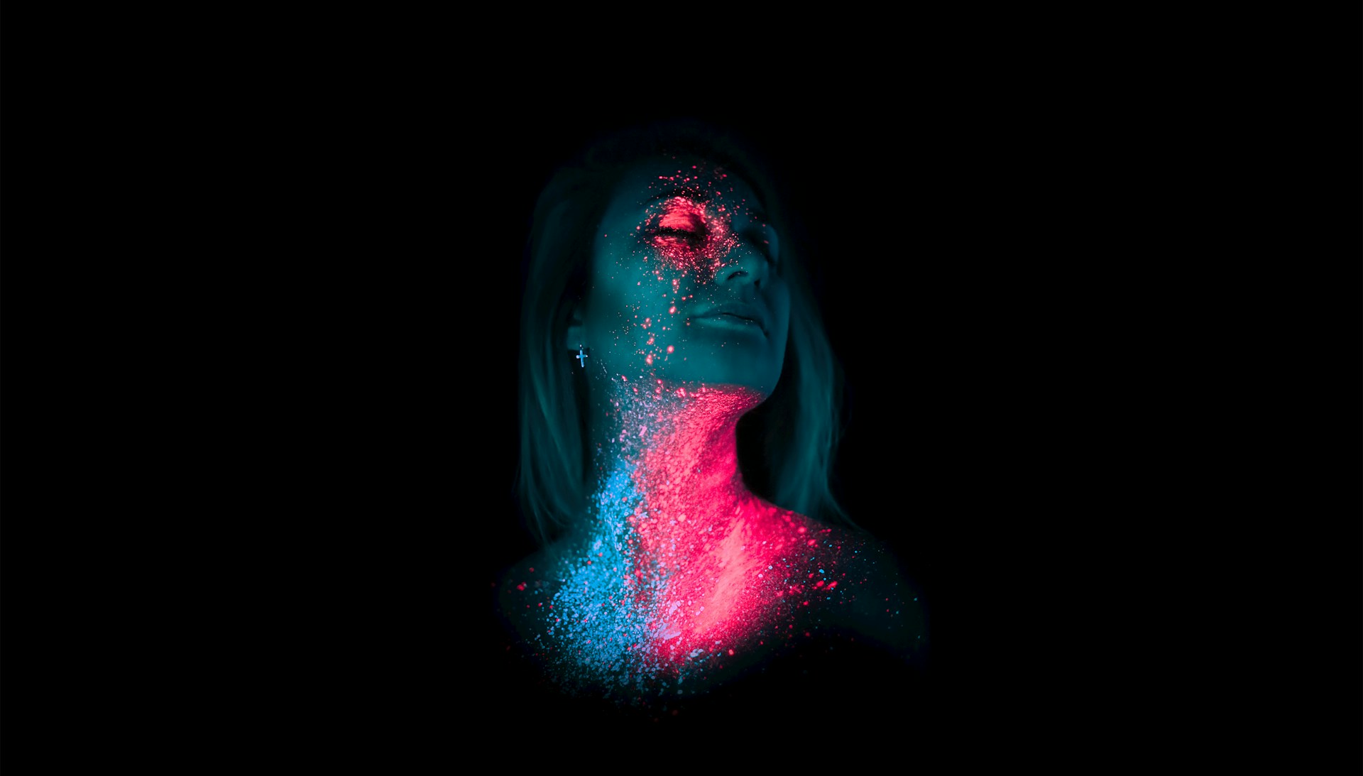 Gezicht en hals van vrouw met fluorescerende verf onder UV licht in blauw-roze gloed