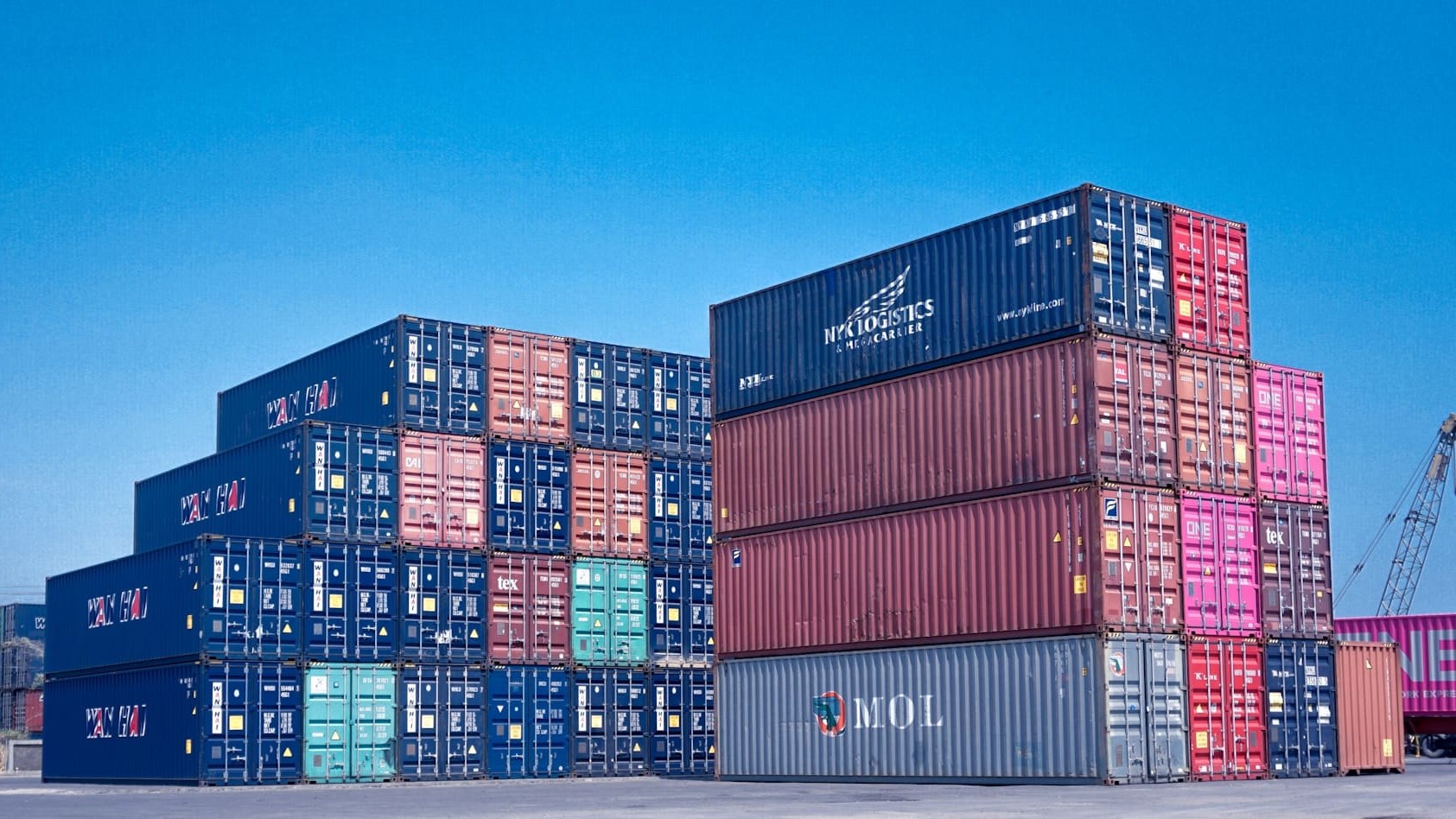Gestapelde zeecontainers op terminal illustreren verschil tussen containeroverslag en bulkoverslag