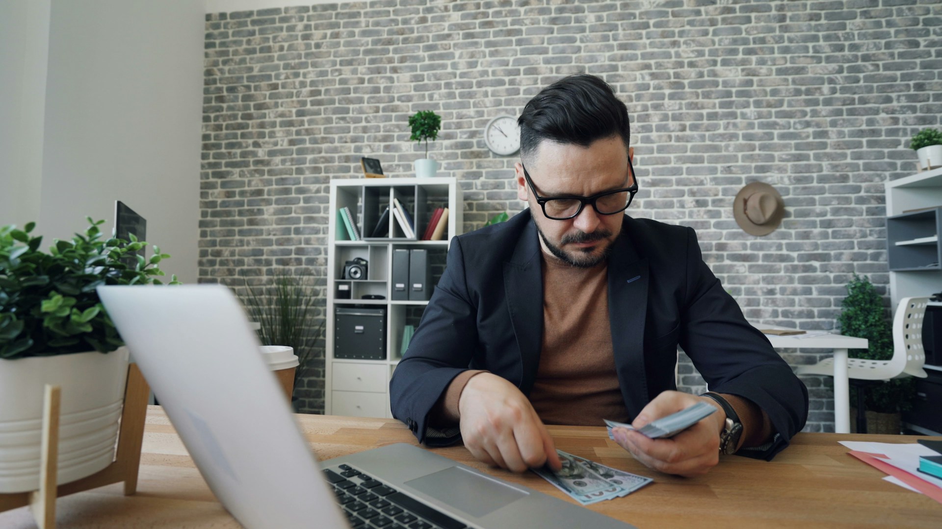 Man controleert geld en administratie bij uitleg over loonheffing en inkomstenbelasting