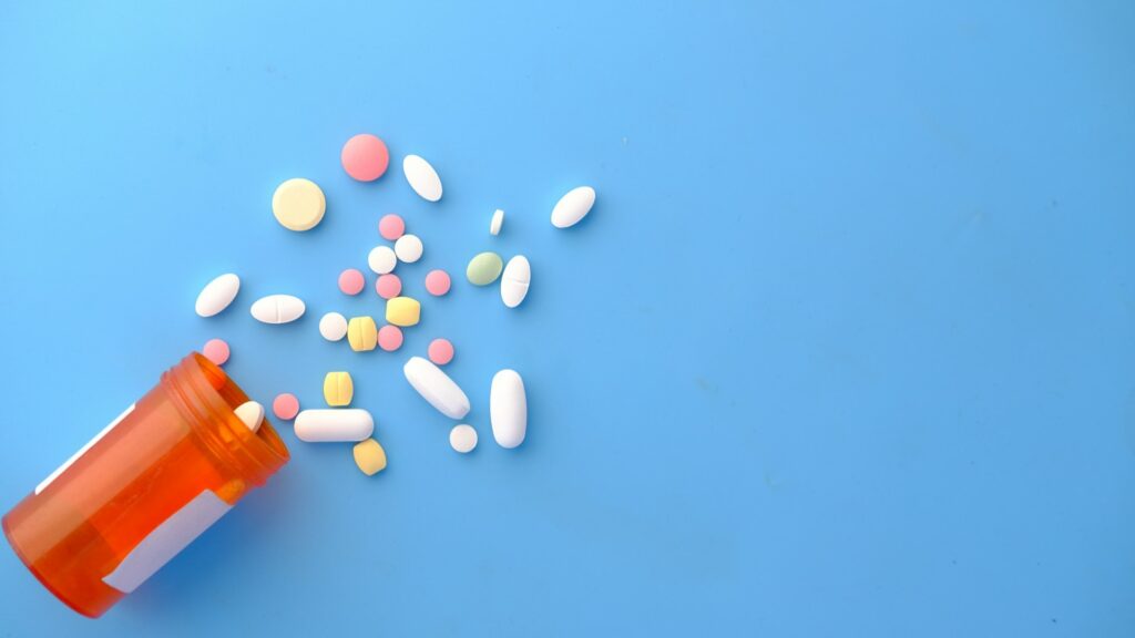 Verspreide pillen uit potje als illustratie bij therapie of medicatie verschil en snelle symptoomverlichting