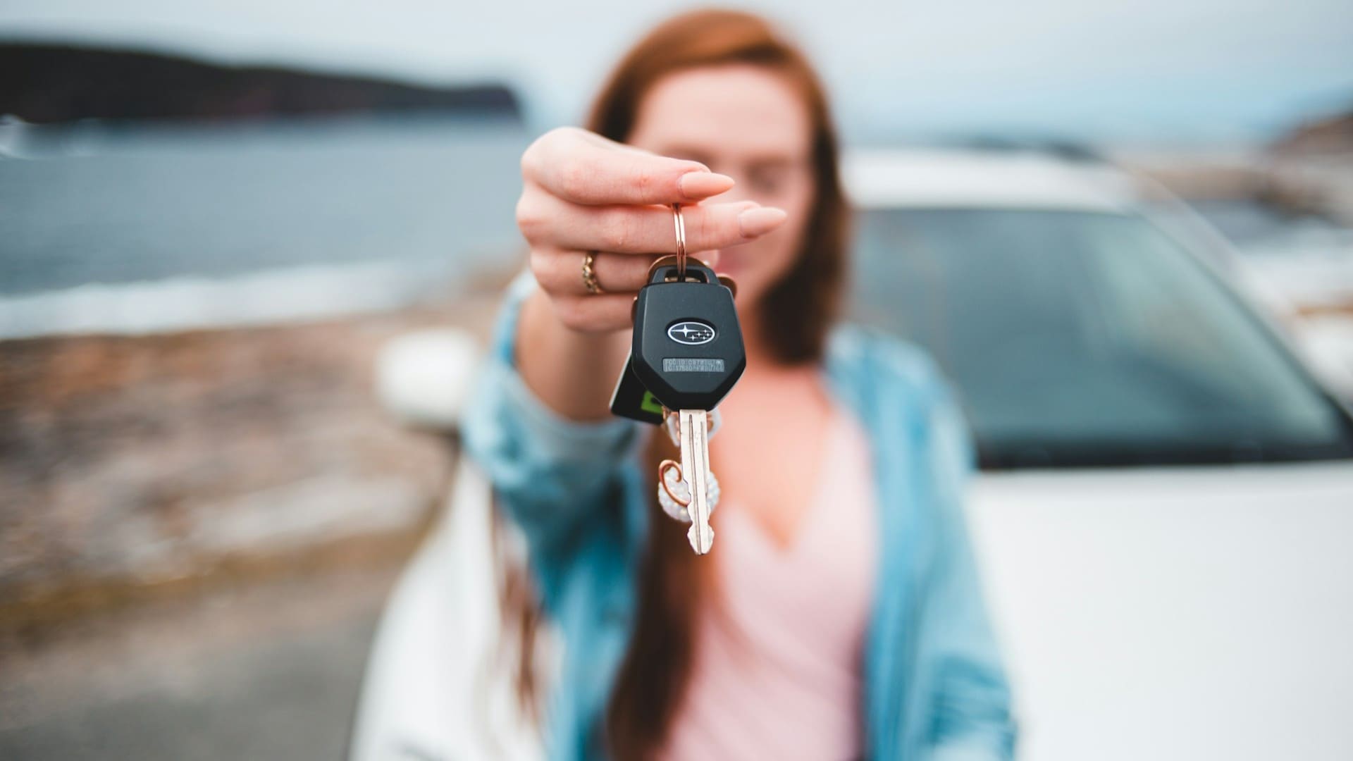 Vrouw houdt autosleutel vast bij nieuwe auto na keuze voor shortlease
