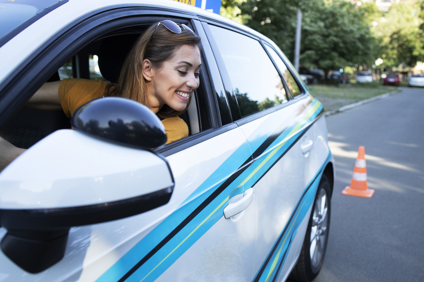 Leerling oefent achteruit rijden tijdens rijles in een lesauto.